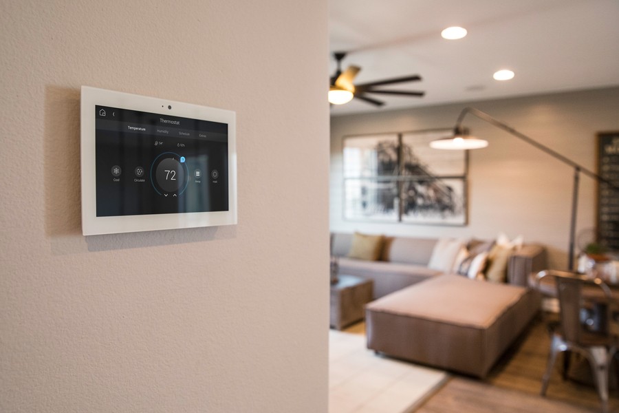 A wall-mounted Control4 interface featuring climate control options. 