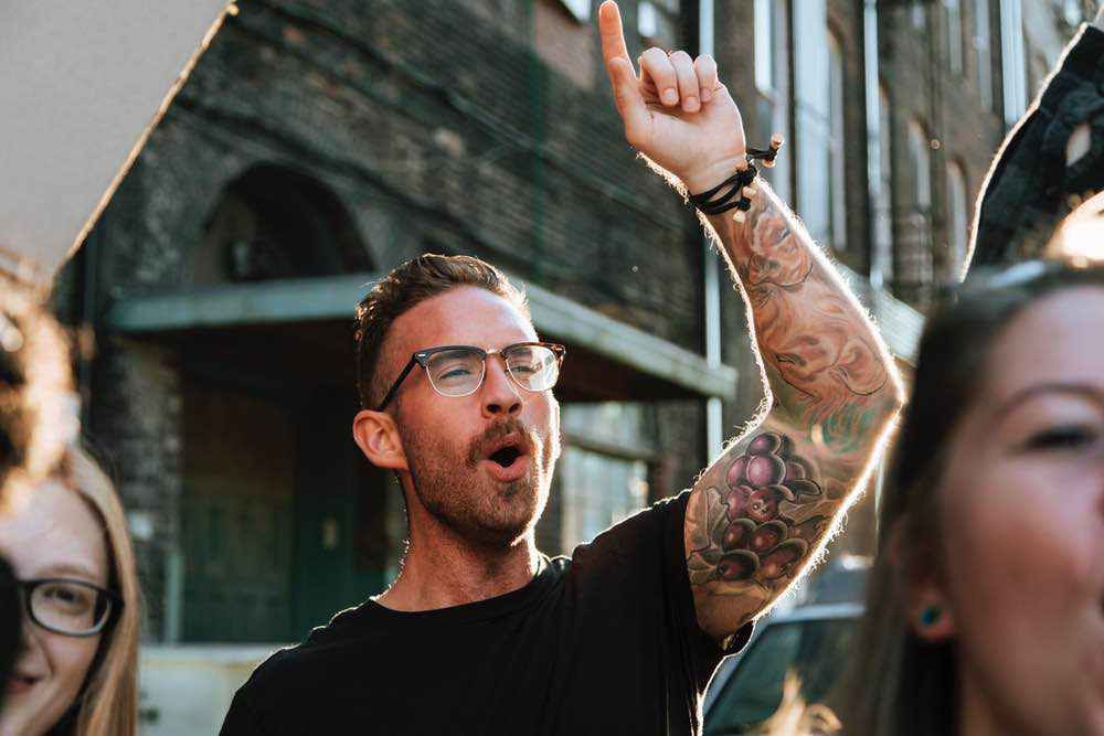 man with glasses, raising hands